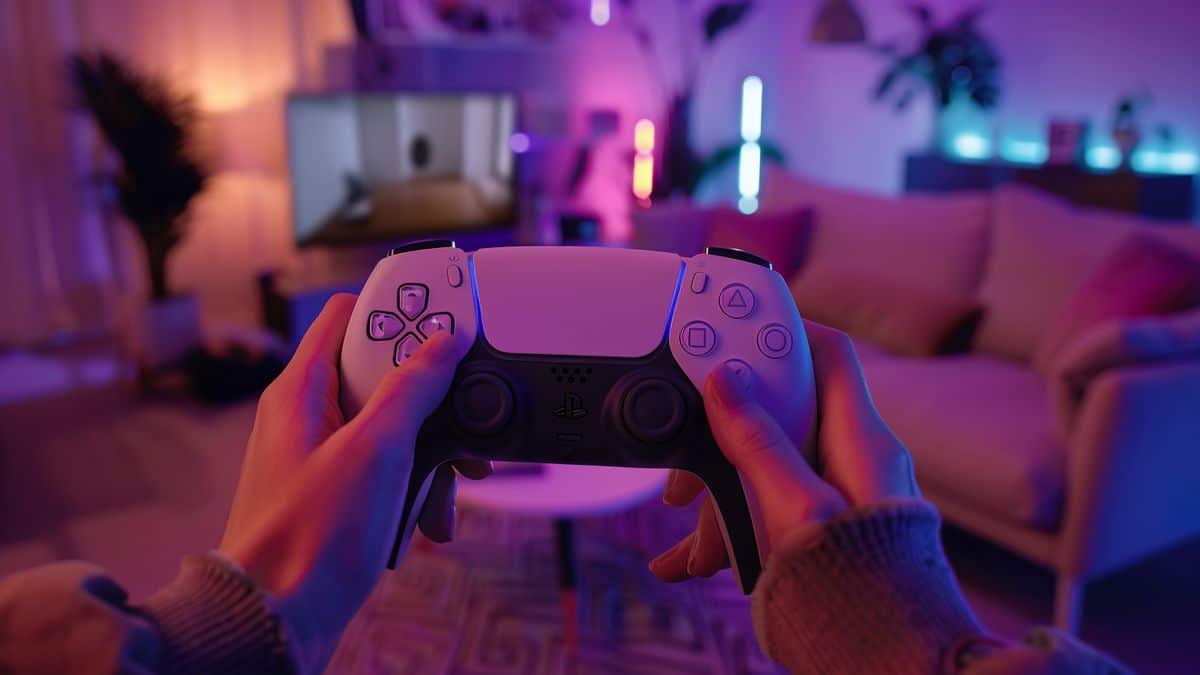 Player holding the DualSense controller, showcasing its immersive features in V Rising.