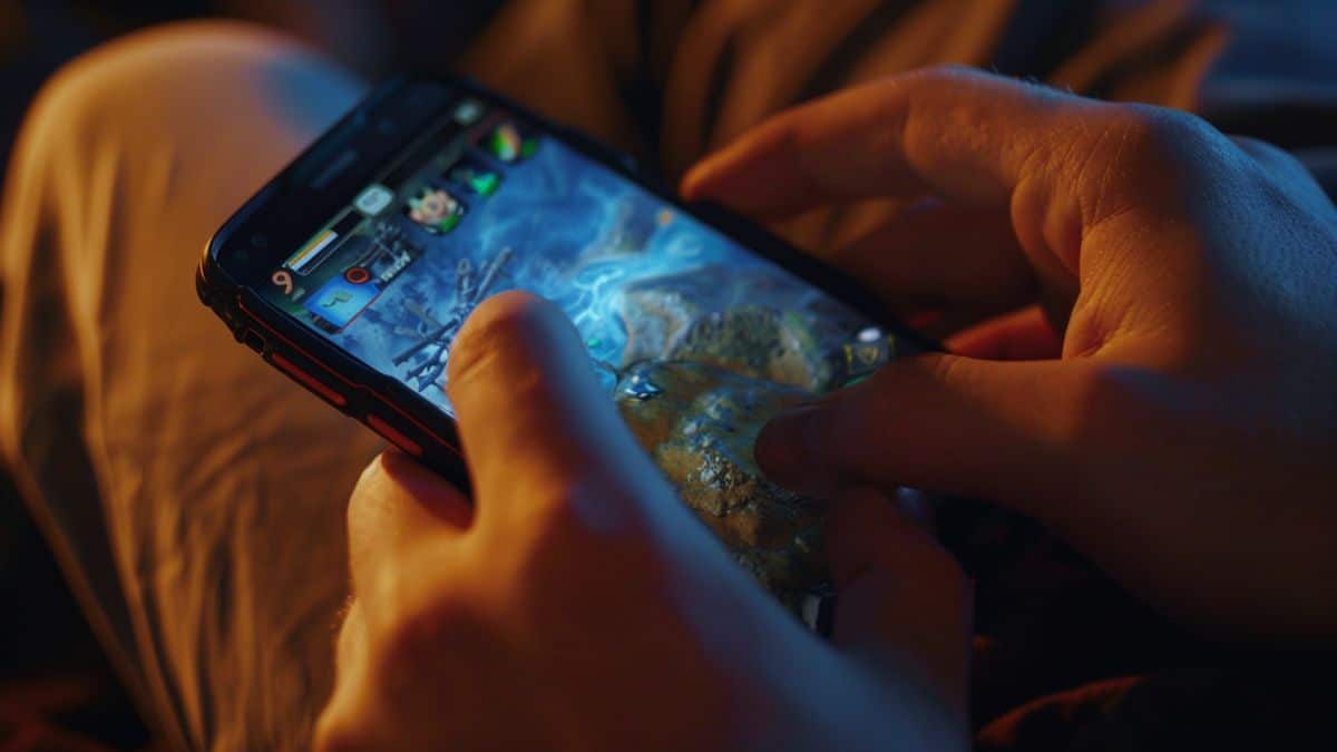 Closeup of a player checking daily quests on their phone.